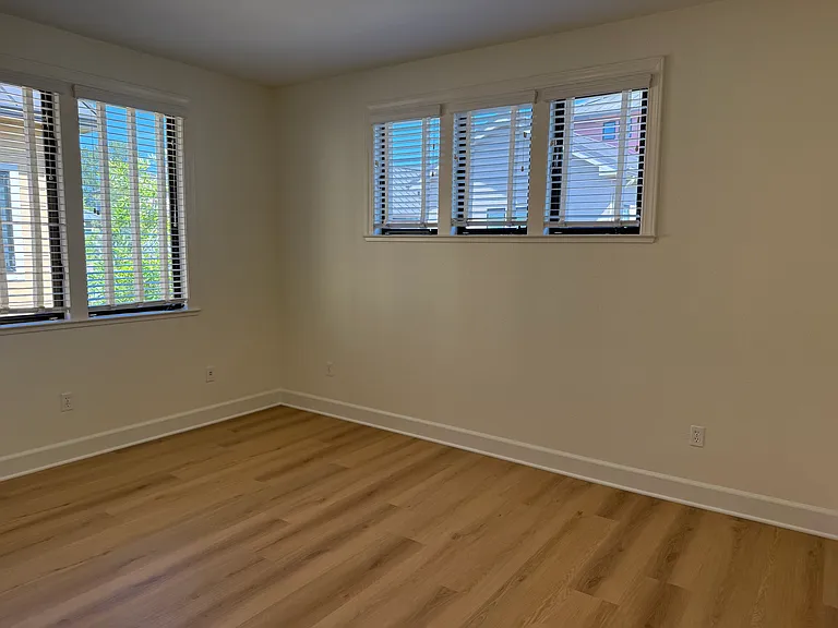 Spacious Bedroom #1 features multiple windows, vinyl flooring, walk-in closet, a separate bathroom sink and share a Jack-and-Jill style bathroom for the bathtub and toilet.