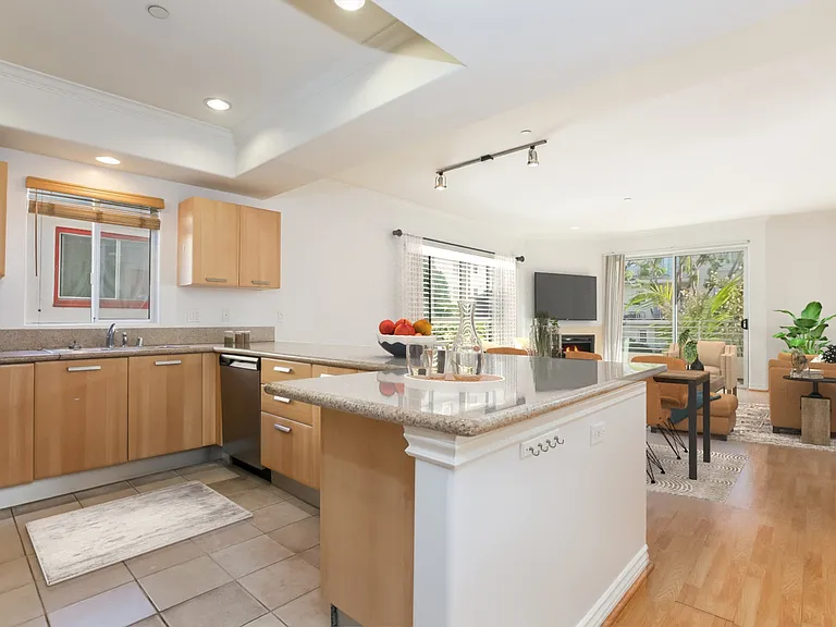 Kitchen looking towards living room and balcony virtually staged