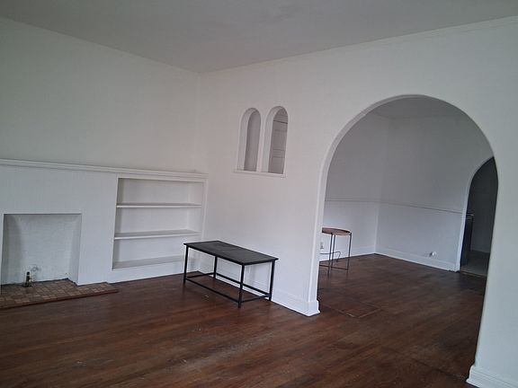 Space #1: Large entry/living room with archway leading to dining room.