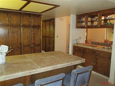 Breakfast Bar showing extra storage cabinets down the Hallway and Wet Bar separating the dining room.