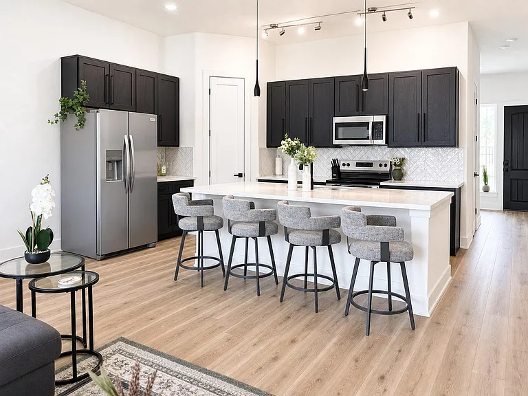 Open-concept kitchen with a large island breakfast bar, ample cabinetry, and stainless-steel appliances for everyday cooking.