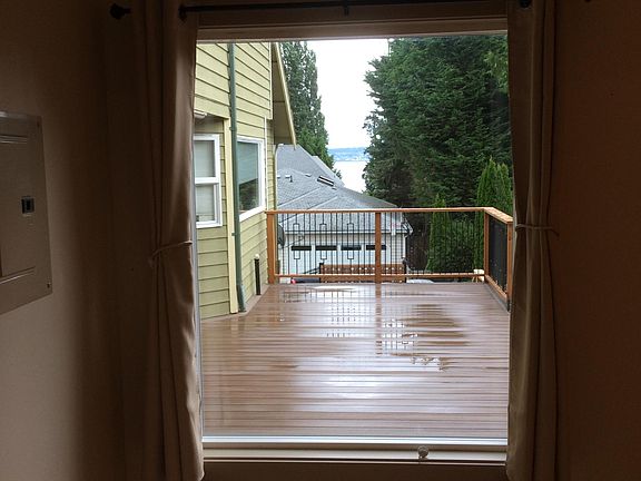 Looking East out window across deck with small view of Puget sound.