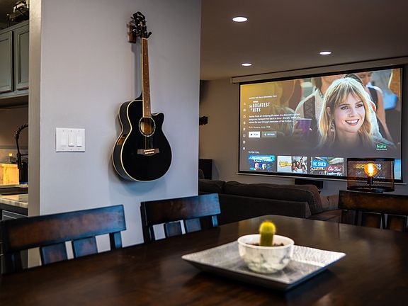 Dining room table with view of living room and projector screen
