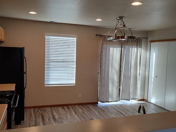 Kitchen - gray/tan laminate flooring, sliding door from kitchen to backyard area