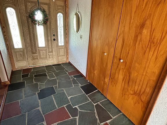 Entryway with slate floor and wide coat closet
