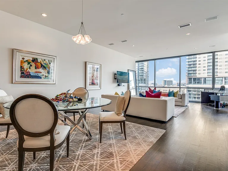 Dining room with a wall of windows, wood finished floors, recessed lighting, and a chandelier