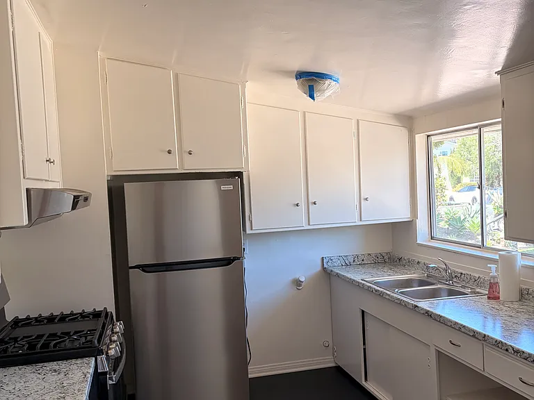 Kitchen with new flooring, new stove, new overhead fan, new refrigerator