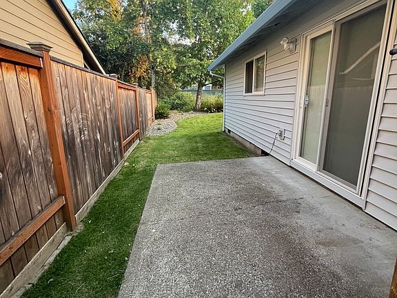 Patio door to backyard with concrete pad.