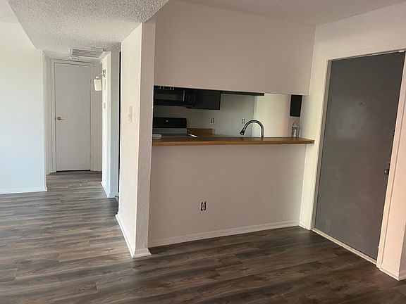 View from master bedroom into living area, kitchen and front door