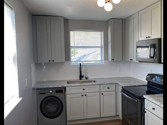 Kitchen with washer and dryer in unit.