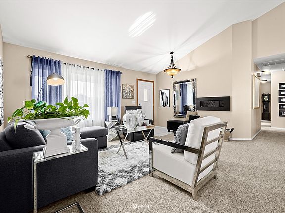  Open living room with vaulted ceiling accented by quaint bay window.