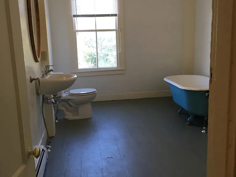 Huge bathroom with clawfoot tub and cement shower