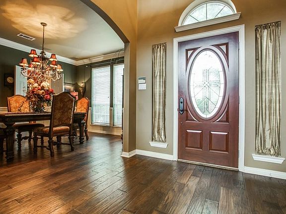 Beautiful wide plank wood flooring accent spacious foyer and dining room with updated Chandelier.