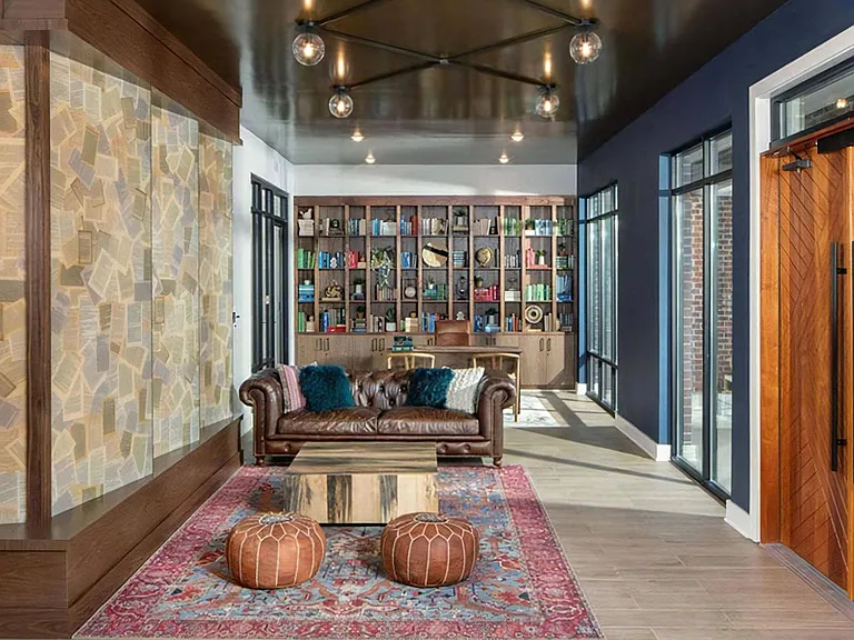 Community Lounge Featuring Leather Sofa, Library Wall, and Designer Lighting