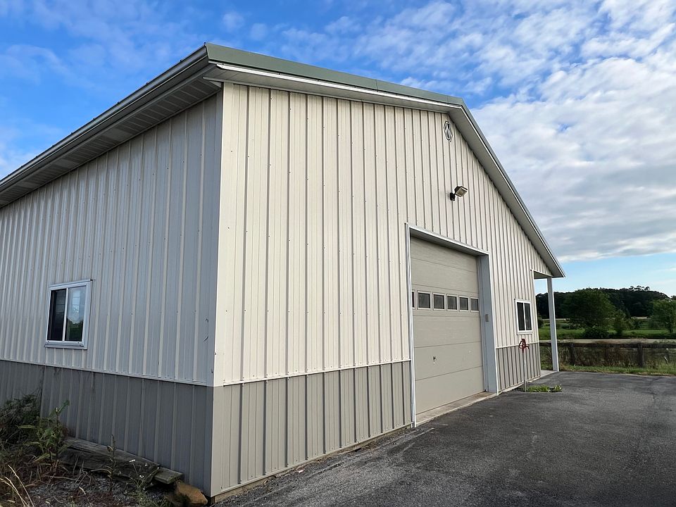 Large barn with three stalls and two large overhead doors