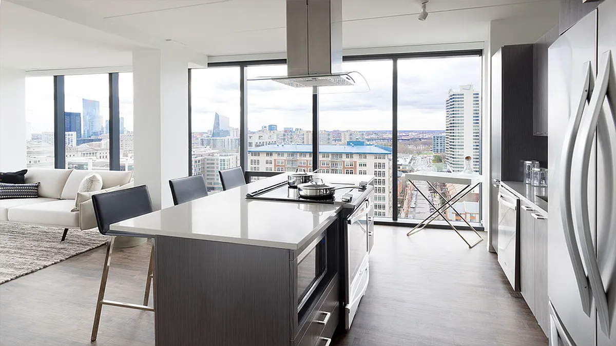 Large kitchen island with sleek gas cooktop looking into living surrounded by floor to ceiling windows - 450 N 18th St