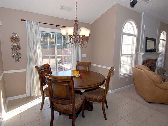 Breakfast area features new tile, upgraded light fixture, & lush backyard view