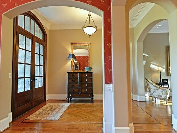 Upon entry the custom design is obvious.  Herringbone hardwood inlay, rounded corners, heavy crown and chair moldings, arched room entries and open design.  Lovely double mahogany door with transoms.