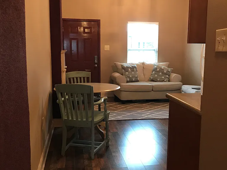 Living/dining/kitchen open area looking from hallway. Furniture is not included
