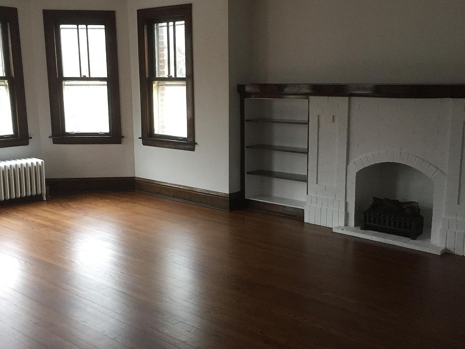 19'7" x 16'5" Living room with built-in bookshelves and decorative fireplace.