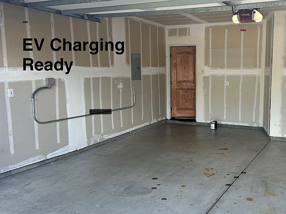 Inside two car garage, EV charge ready and door to family room/ kitchen area