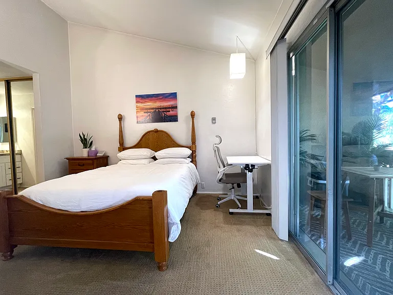 Secondary bedroom with patio doors and automatic vertical blinds
