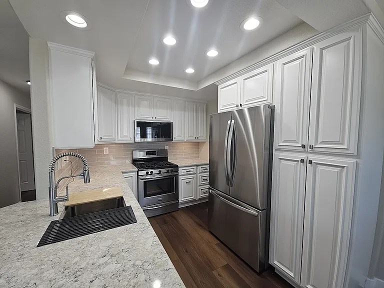 Fully remodeled kitchen with quartz countertops, new appliances, and oodles of light