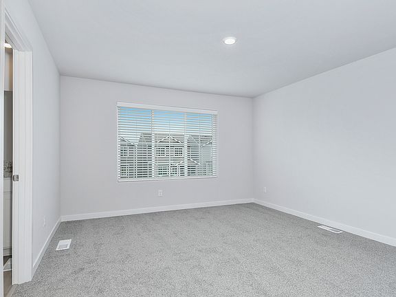 The master bedroom is spacious with a large window.