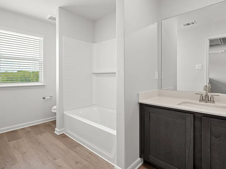 The secondary bathroom has a sprawling vanity and shower-tub combo.