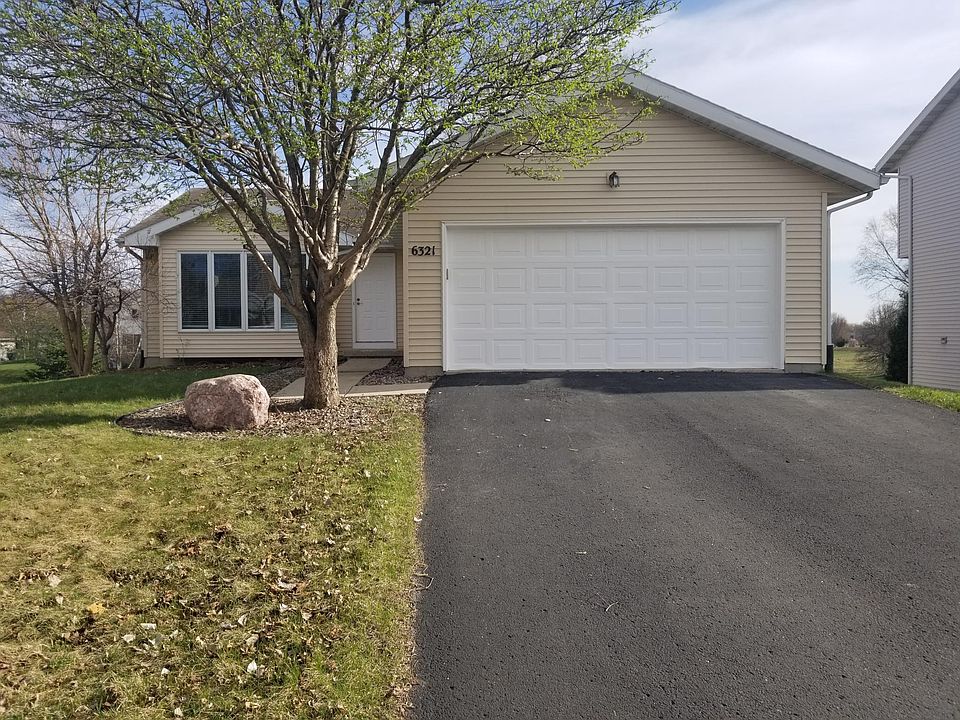 Front of house with a 2 car garage, driveway and street parking.