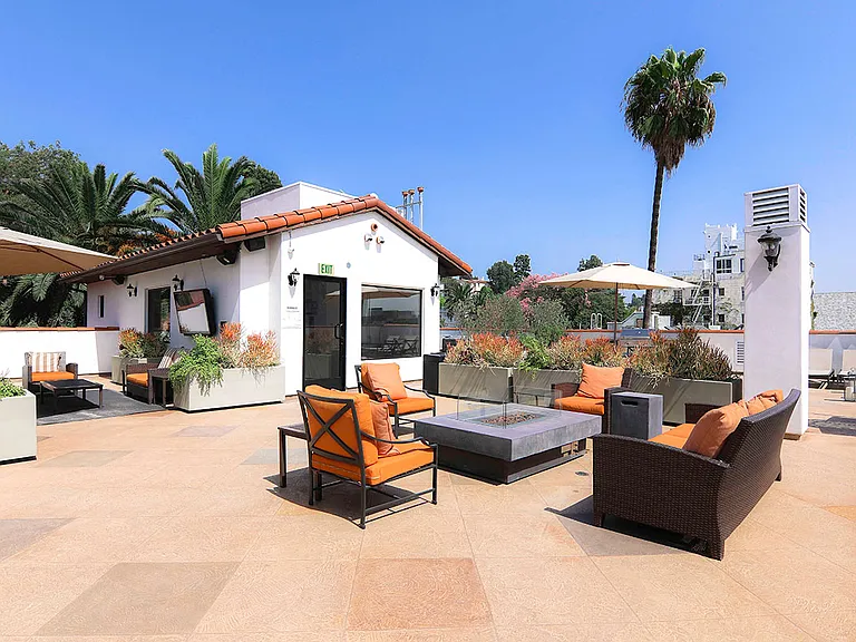 Open air rooftop patio with gas firepit, BBQs, several seating locations, and cable television.