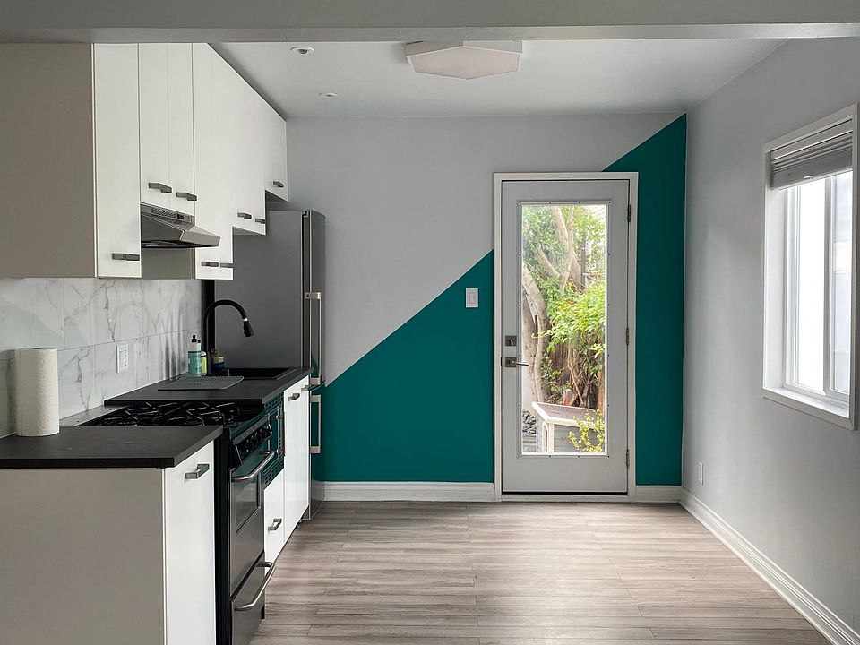 Triangle accent wall, open concept kitchen, geometric 3d ceiling in living room.