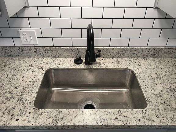 Farm style sink with retractable faucet and garbage disposal.