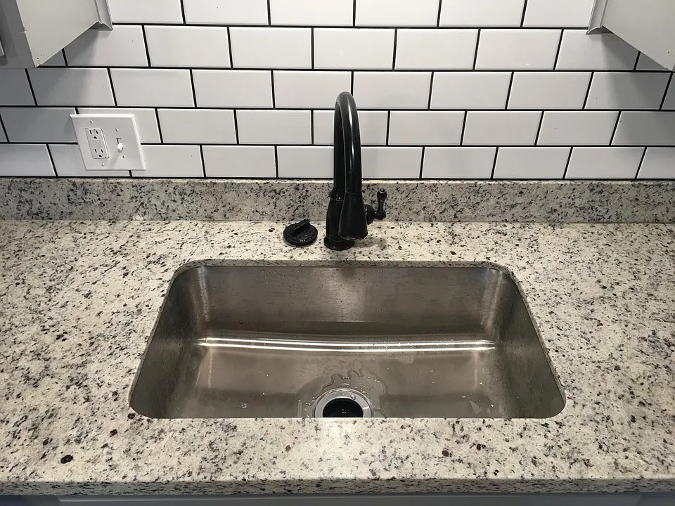 Farm style sink with retractable faucet and garbage disposal.