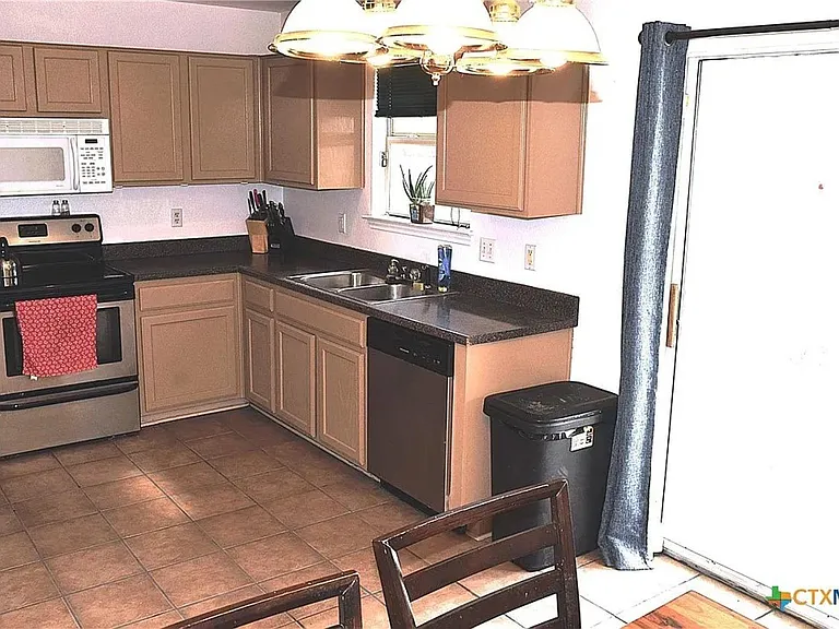 Kitchen with coffee maker, microwave, oven/stove, cookware, cutlery, and full size fri