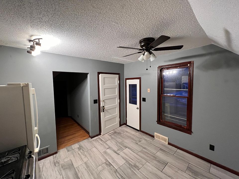 Kitchen facing lead to the living room, entrance door to stairwell, and door to outside viewing deck