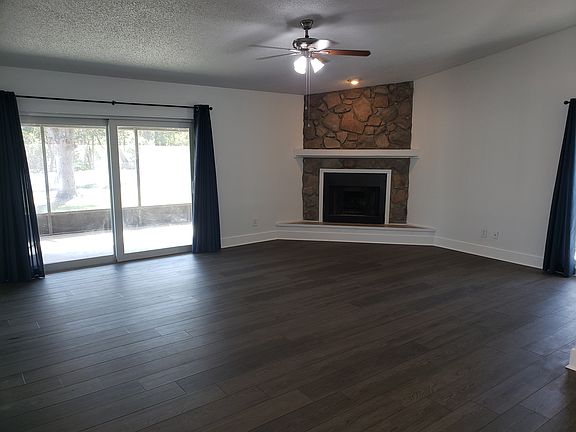 Large great room with fireplace and slider to screened patio.
