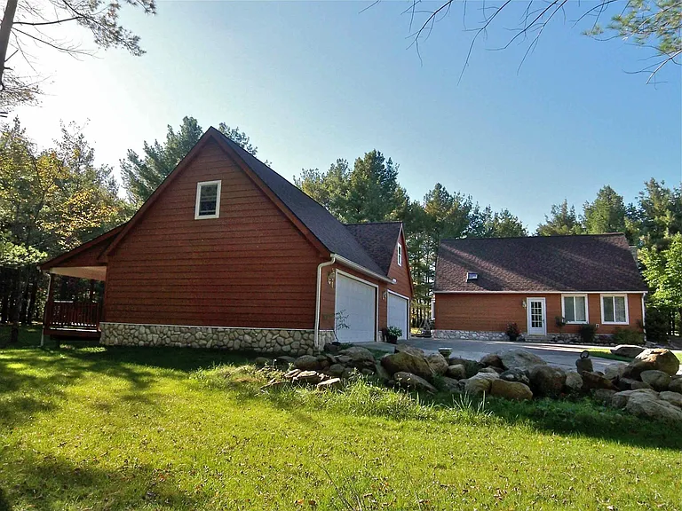 Side view of garage with house in background.