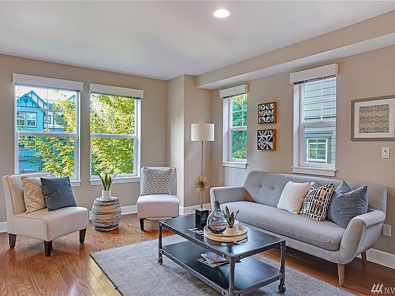 Living room with hardwood floors, loads of windows for plenty of natural light and custom valences.