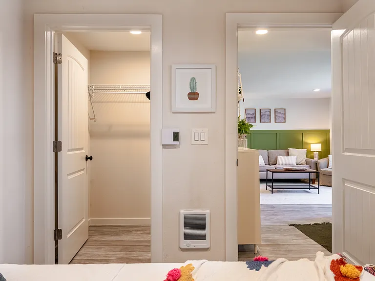 Second bedroom with full size bed view into the living room, walk in closet