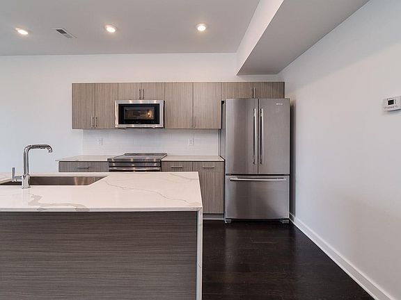 Beautiful Gray Tones, Quartz Countertops and a Waterfall Edge on the Island. Stainless Steel Jenn-Air Appliances including Induction Range.