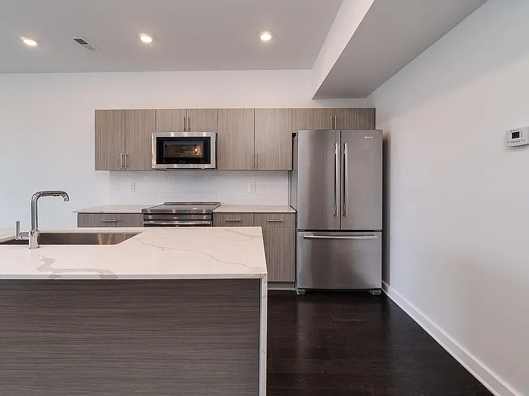 Beautiful Gray Tones, Quartz Countertops and a Waterfall Edge on the Island. Stainless Steel Jenn-Air Appliances including Induction Range.