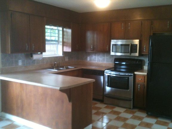 Kitchen features stainless and black appliances