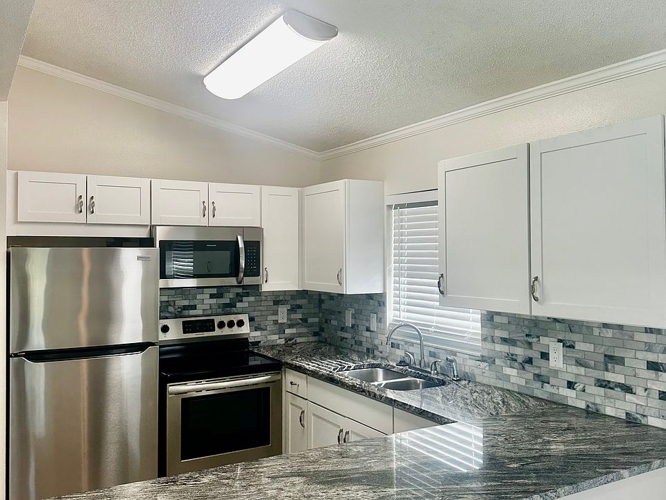 Granite countertops and stainless steel appliances with big food pantry in the kitchen.