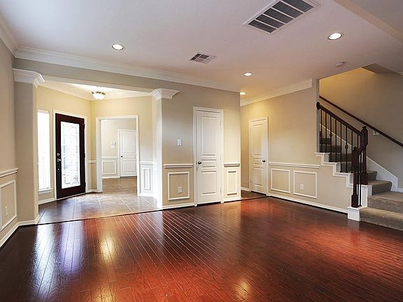 Dining Area and view of entry, staircase with iron balusters.