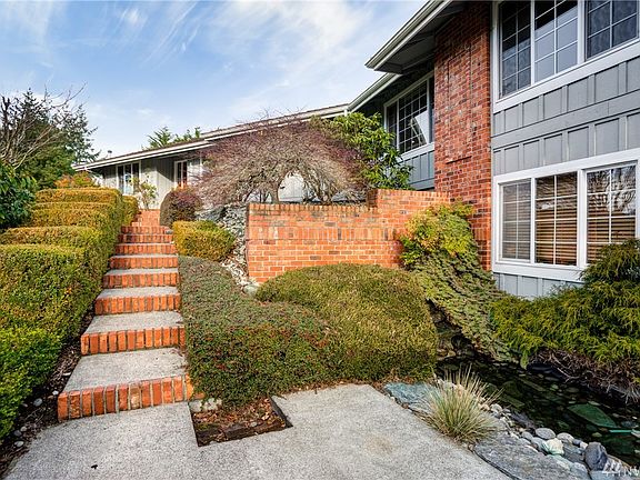 Beautiful brick detailed steps leading to the front entrance with soothing pond and waterfall. 