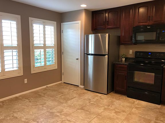 Natural light in kitchen, pantry, and new stainless steel fridge.