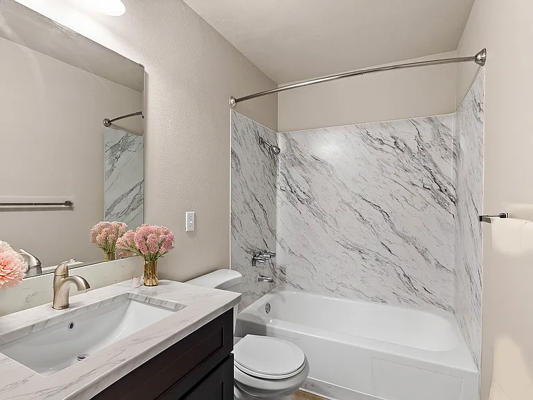 Experience luxury in this beautifully designed bathroom featuring stunning marble and chic fixtures.