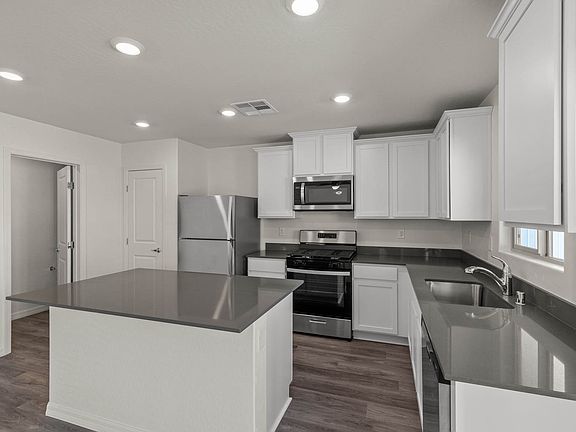 The kitchen of the Cypress has white wood cabinetry.