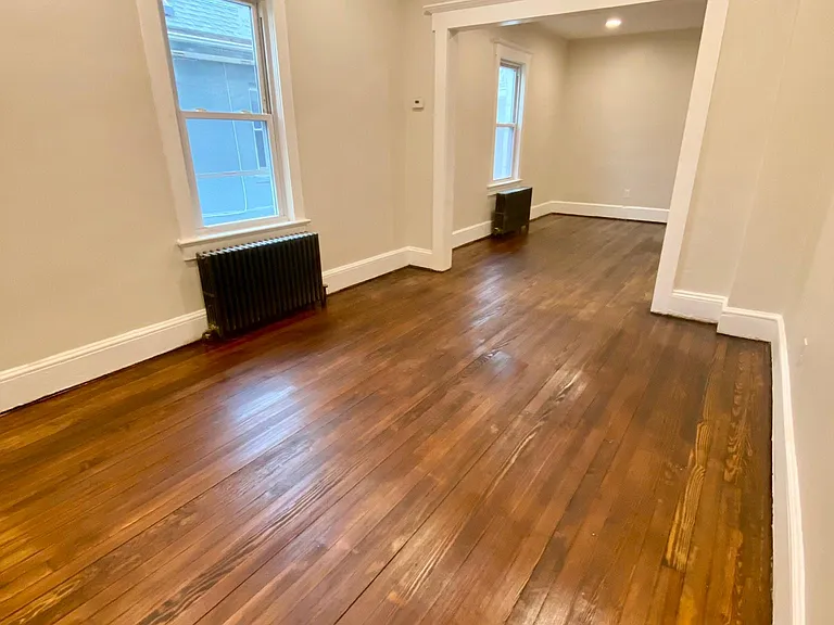 view of living room leading to full size dining room, freshly refurbished hardwood floors with wide moldings and LED recessed lighting. Lots of room. 13x 10
